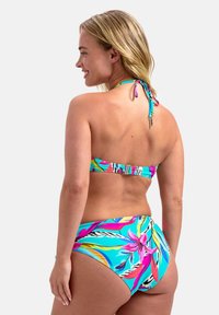 Zestaw bikini z kolorowym kwiatowym wzorem na jasnoniebieskim tle, z trokami na szyi i plecach oraz elastyczną fakturowaną tkaniną.