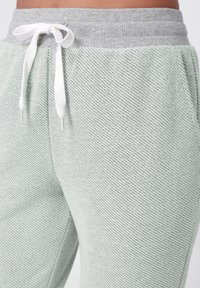 Lichtgroene, gestructureerde joggers met een grijze ribbelint en witte trekkoorden, met een ontspannen pasvorm ontwerp.