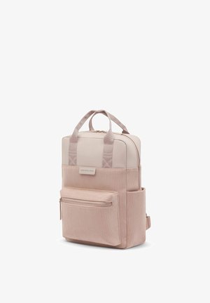 Sac à dos en velours côtelé rose clair avec poche zippée à l'avant, poche latérale, double poignée supérieure et étiquette Kapten & Son sur le panneau avant.