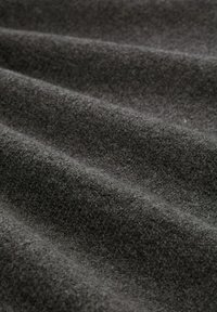 Dunkelgrauer Wollstoff mit einer weichen, strukturierten Oberfläche, die sich durch überlappende Falten und einen leichten Glanz auszeichnet.