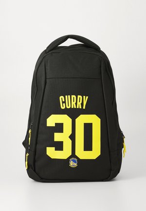 Black backpack with yellow "CURRY 30" text and Golden State Warriors logo on the front pocket with yellow zipper pulls.