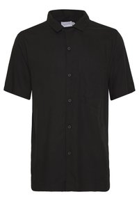 Lyhythihainen, nappikiinnitteinen paita yksivärisenä mustana, jossa on kaulus, rintatasku ja sileä, kevyt kangas. Klassinen istuvuus.