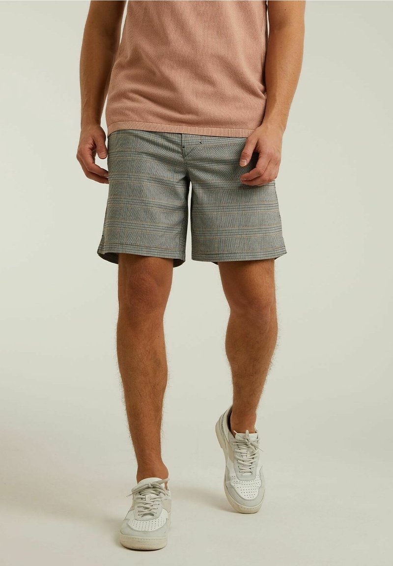 Shorts gris à carreaux avec une coupe ajustée, présentant un motif de checks subtil et un tissu léger. Portés avec une chemise texturée rose clair.