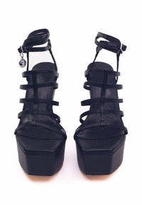 Sandali con piattaforma neri con punta chiusa, più cinturini, fibbia alla caviglia e tacco spesso. Realizzati in materiale sintetico liscio.