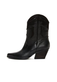 Botas de cowboy de cuero negro con punta afilada, costuras decorativas en la parte superior y un tacón de madera en forma cónica. Textura suave en toda la bota.
