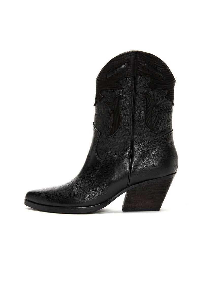 Botas de cowboy de cuero negro con punta afilada, costuras decorativas en la parte superior y un tacón de madera en forma cónica. Textura suave en toda la bota.