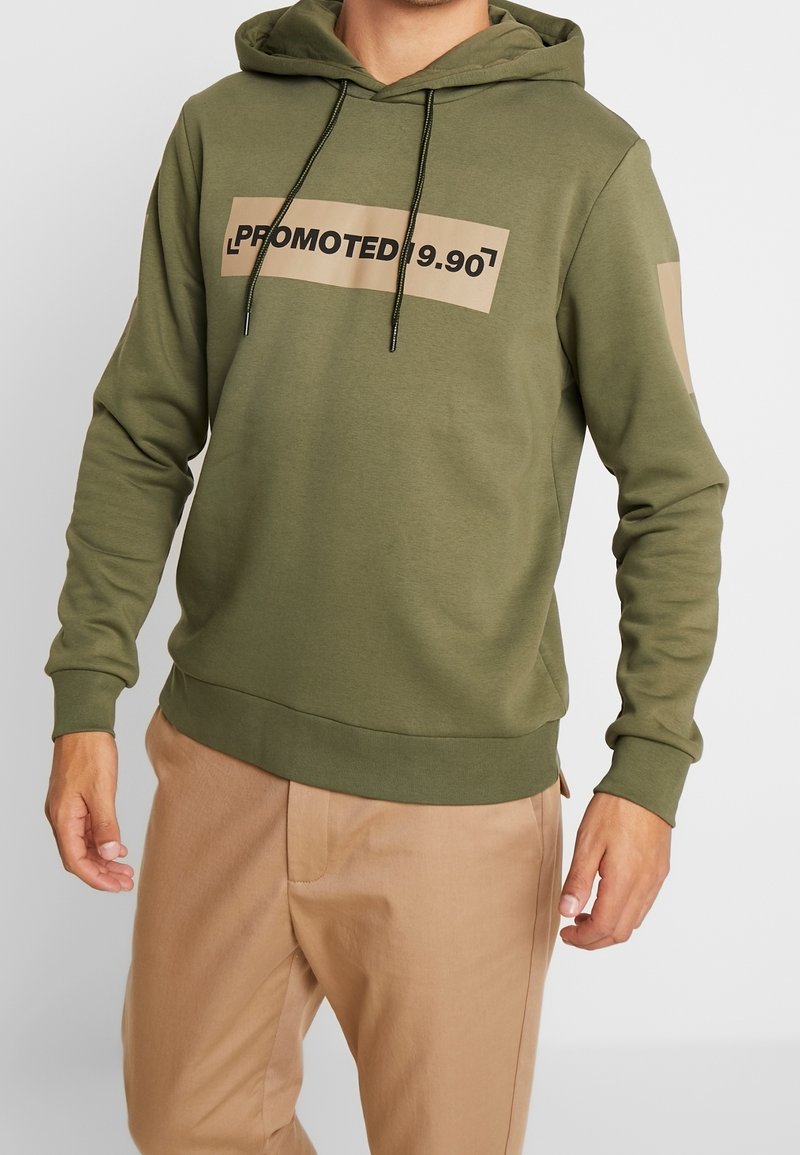 Oliwkowy hoodie z kangurzą kieszenią, regulowanym kapturkiem na sznurki i dużą beżową grafiką nadrukowaną z przodu z napisem "PROMOTED 9.90".
