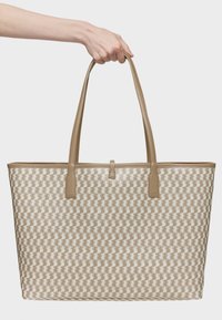 Bolso grande tipo tote con un patrón tejido en tonos crema y beige. Cuenta con asas de cuero beige suave y una forma rectangular.