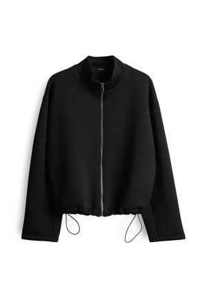 Giacca nera corta con colletto alto, chiusura frontale con zip e orlo regolabile con cordino. Realizzata in un tessuto liscio e strutturato.