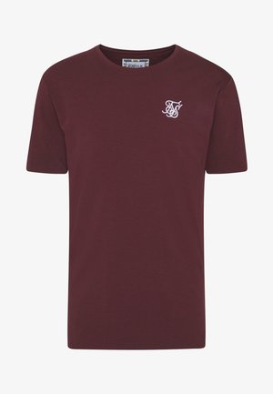 Maroonfarbenes T-Shirt mit kurzen Ärmeln und Rundhalsausschnitt, mit kleinem weißem gesticktem Logo auf der linken Brust und sichtbarem Markenetikett innen am Kragen.