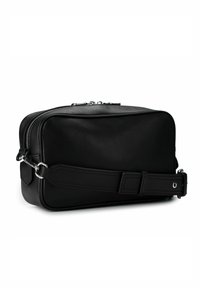 Schwarze Ledertasche mit rechteckiger Form, ausgestattet mit Reißverschluss, abnehmbarem Riemen und silbernen Metallakzenten. Glatte Textur.