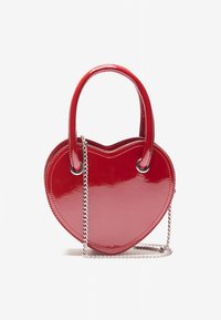Red heart-shaped handbag made of patent leather with a glossy finish. Features two handles and a removable metal chain strap.