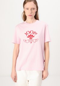 Růžové bavlněné tričko s červeným potiskem loga "JOOP! JEANS", krátkými rukávy a volným střihem; minimální švy a postranní rozparky.
