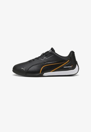 Baskets noires Puma McLaren Racing à profil bas avec accents orange et blanc, fermeture à lacets et panneau latéral perforé pour la ventilation.