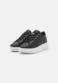 Sneaker in pelle nera con design trapuntato, suola in gomma bianca, lacci piatti e dettagli con logo sulla linguetta e sul lato.