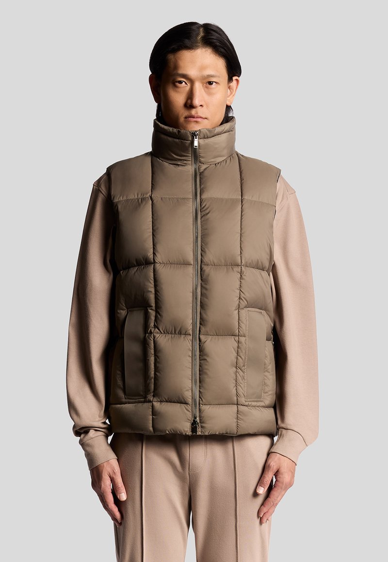 Gepolsterte olivgrüne Weste mit hohem Kragen, Frontreißverschluss und Seitentaschen. Glatte Oberflächenstruktur und rechteckiges Steppmuster.