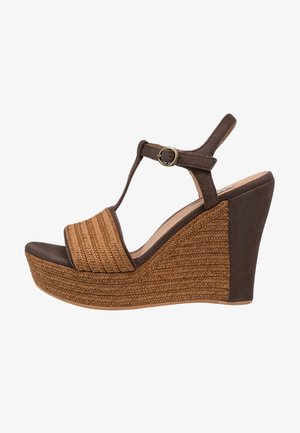 Sandalia cuña marrón con plataforma de textura tejida, tira en T y cierre con hebilla dorada en la correa del tobillo.