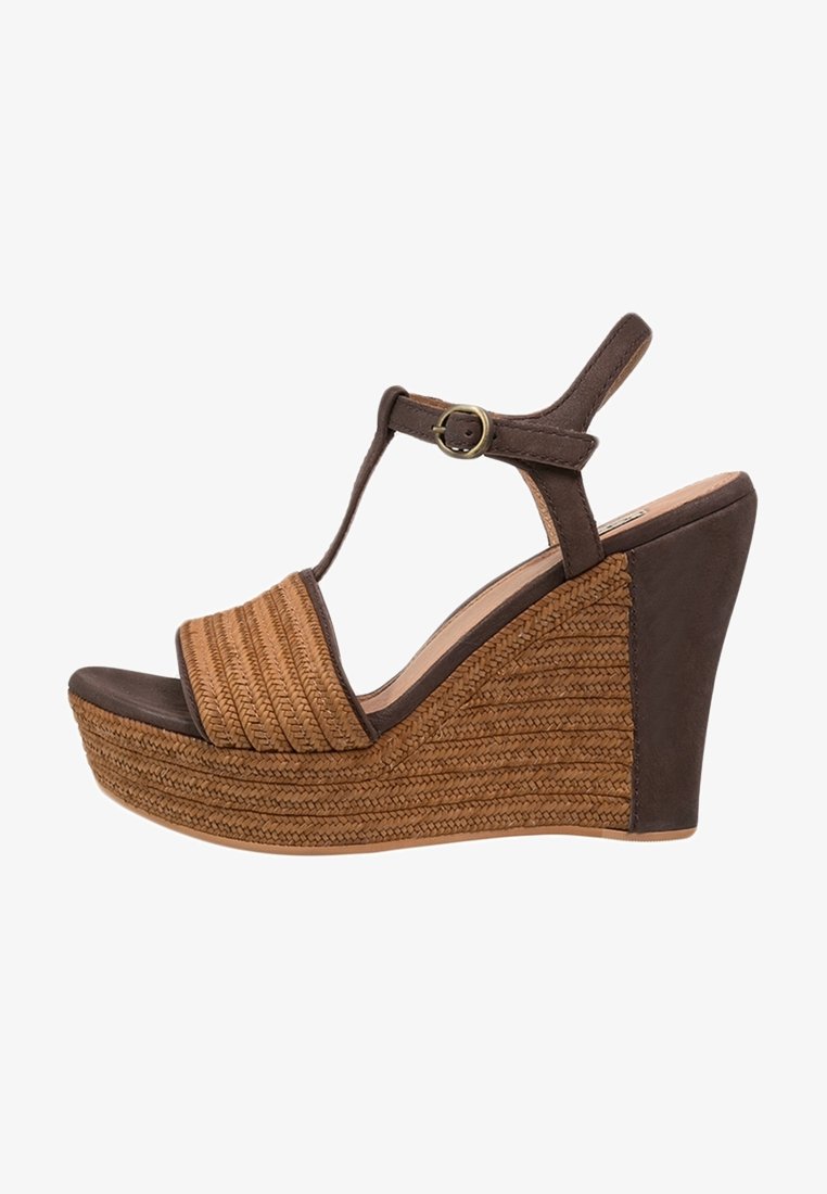 Sandale compensée marron avec plateforme à texture tissée, bride en T et fermeture boucle dorée sur la bride de la cheville.