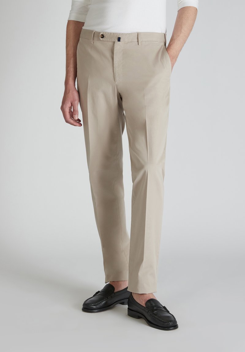 Pantaloni beige su misura in tessuto leggero, con una parte anteriore piatta, due tasche laterali e una chiusura con un bottone singolo con un accento a contrasto.
