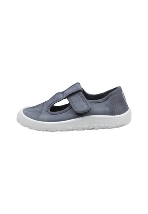 Zapatilla infantil de lona gris con suela de goma blanca, con cierre de velcro y diseño recortado en el lateral para mayor transpirabilidad.