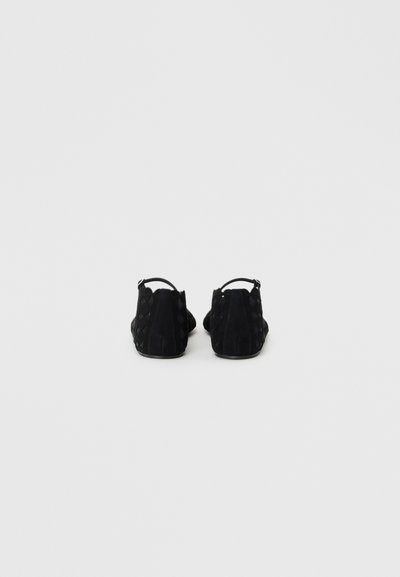 Black suede shoes with a textured woven pattern, open back, and slim ankle strap. Critically low-cut design without visible laces.