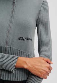 Kratka jakna sa zatvaračem od meke, melirane sive tkanine; rebrasta tekstura na rukavima i dnu; s izvezenim logotipom "KARL LAGERFELD JEANS".