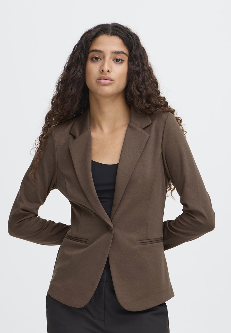 Brown fitted blazer made of smooth fabric. Features a single-button closure, notched lapels, and two front pockets. Long sleeves.