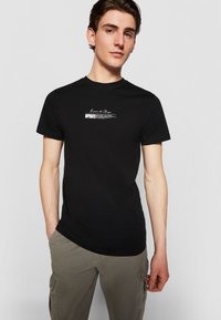 Black cotton T-shirt with round neck, short sleeves, and white printed text: "Born to Change" and "BUTTERFLI" on the front.