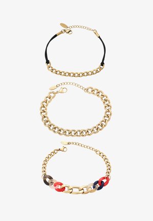 Drie armbanden met goudkleurige ketting: één met zwart koord, één dikke getextureerde en één met multicolor hars schakels in rood, marineblauw en beige.