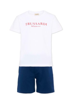 T-shirt bianca a maniche corte con scritta rossa "TRUSSARDI Milano 1911" abbinata a pantaloncini blu navy semplici.