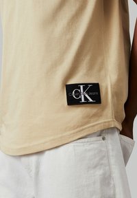 Calvin Klein Jeans BADGE TURN UP SLEEVE - Camiseta básica - pale khaki
