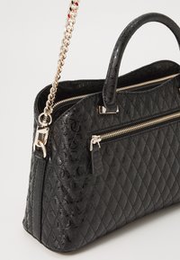 Borsa a tracolla nera trapuntata con finitura testurizzata, hardware in tonalità argento, doppi manici superiori e tracolla a catena rimovibile. Presenta tasche con cerniera.