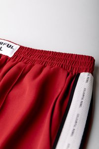 Röda shorts med elastisk midja som har mjukt tyg och svarta och vita sidsömmar. Etiketten på midjan säger "COLORFUL REBEL."