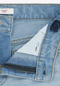 Ανοιχτό μπλε τζιν σορτς με φερμουάρ και κουμπί. Διαθέτει ετικέτα με την επιγραφή '94 Baggy Short' και ραφές σε αντίθετο χρώμα.