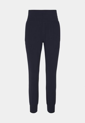 Navy blue jogger pants made of soft fabric, featuring a wide waistband, two side pockets, and ribbed cuffs at the ankles.