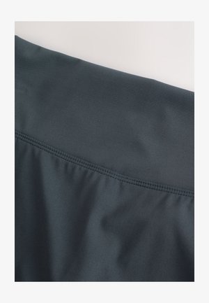 Dunkelgrauer Stoff mit glatter Textur und leichter Elastizität. Verfügt über eine dezente geraffte Naht entlang der oberen Kante für ein figurbetontes Design.