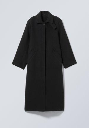 Melnā vilnas mētājam ir apkakles dekoltē, pogu aizvēršana un divas sānu kabatas. Tās taisnais griezums nodrošina strukturētu siluetu.