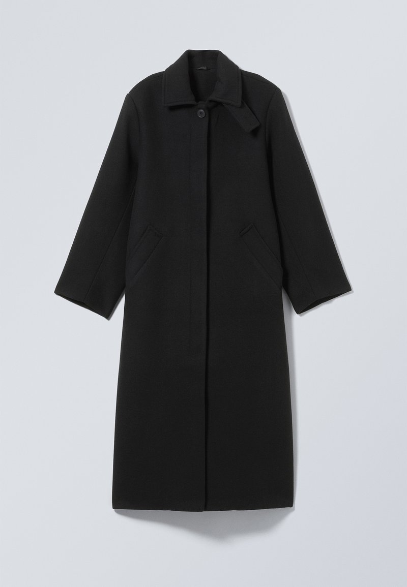 Un manteau noir en laine avec un col, une fermeture à boutons et deux poches latérales. Sa coupe droite offre une silhouette structurée.
