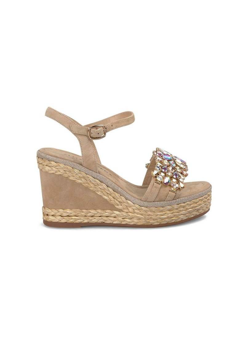Sandale compensée beige avec une tige en daim texturé, une bride de cheville réglable et ornée de cristaux multifacettes sur le devant. Semelle en jute.