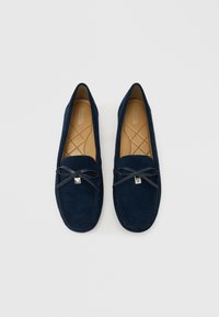 Mocassini in camoscio blu navy con punta rotonda, fiocco decorativo con accento argentato e interno trapuntato. Texture liscia e design elegante.