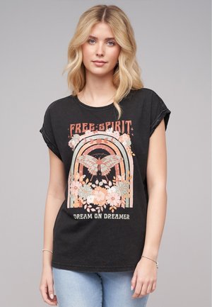 T-shirt graphique noir avec un design de papillon et de fleurs, portant les inscriptions "ESPRIT LIBRE" et "RÊVE ENCORE RÊVEUR" en couleurs pastel. Manches courtes.