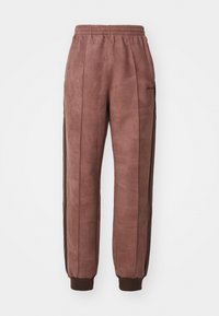 Hnědé, měkké teplákové kalhoty s elastickým pasem a lemy. Mají černé boční pruhy a jemné značkování na přední straně.