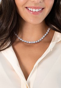 Cultured freshwater pearl necklace with irregular shapes, varying shades of soft blue, and a smooth, reflective texture.