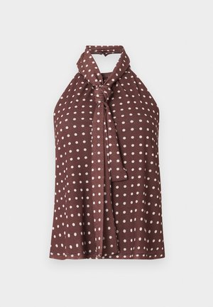 Καφέ αμάνικη μπλούζα halter με λευκές πουά και λεπτομέρεια δεσίματος με κόμπο στον λαιμό, απεικονίζεται σε μονόχρωμο φόντο.