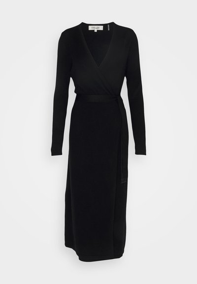 Robe noire en tissu doux, dotée d'un décolleté en V profond et de manches longues, avec une taille à liens et une coupe droite arrivant au milieu du mollet.