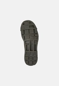 Suola di scarpa in gomma nera con superficie testurizzata, caratterizzata da motivi geometrici e un logo ben visibile, taglia contrassegnata come 42.
