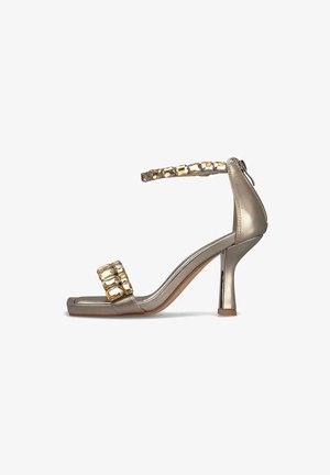 Metallic gold high-heeled sandal with a minimalist design, featuring a square toe, ankle strap, and decorative crystal-like accents.