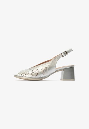 Tacón slingback abierto en plata con empeine de ante perforado con diseño floral y correa ajustable con hebilla.