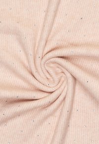 Tessuto di un delicato rosa chiaro con una trama a righe, arricchito da borchie metalliche sparse, creando un sottile interesse visivo.