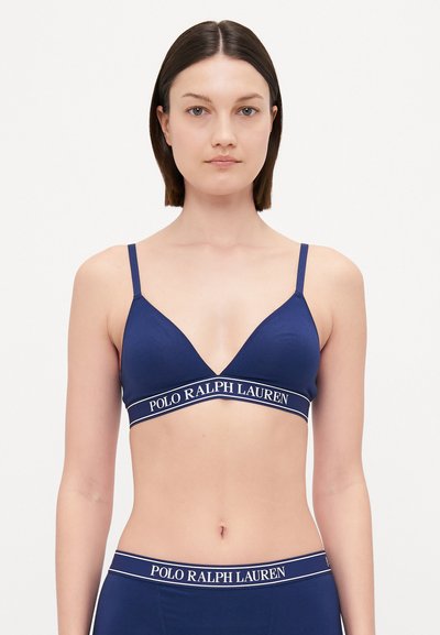 Bralette triangolare blu navy con spalline sottili, caratterizzato da un tessuto testurizzato e da un un logo bianco in contrasto sotto il seno.